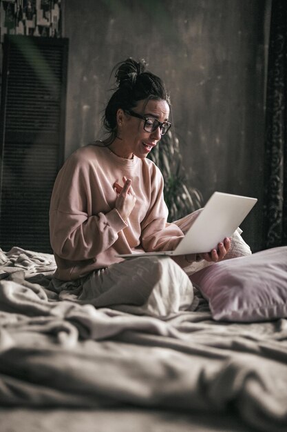 Photo woman sitting on bed at home