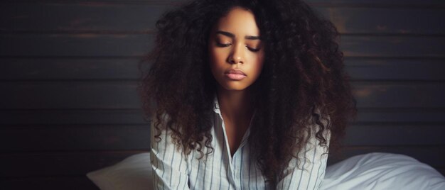 a woman sitting on a bed with her eyes closed