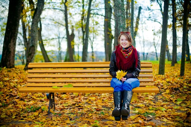 Woman sitting in a bench, autumn mood.