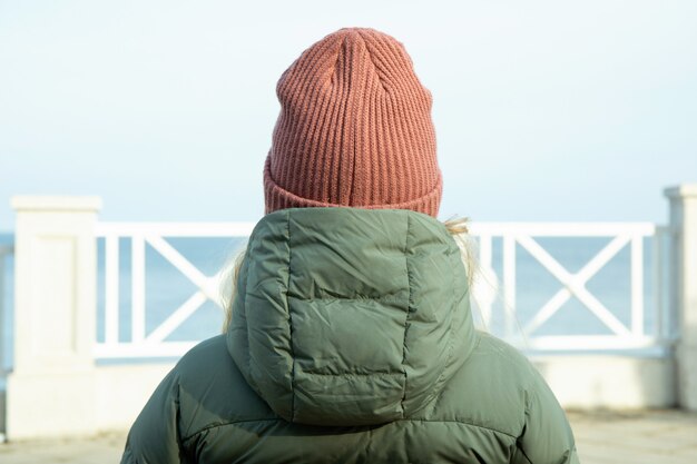 Woman sitting on bench on embankment with amazing view on sea