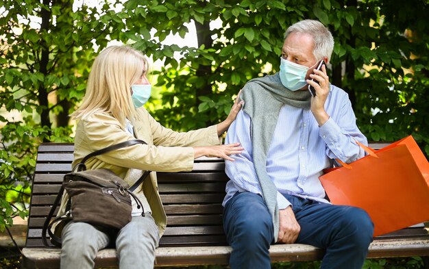 Woman sitting on a bench getting angry because a man dowsn't care about social distancing during coronavirus times