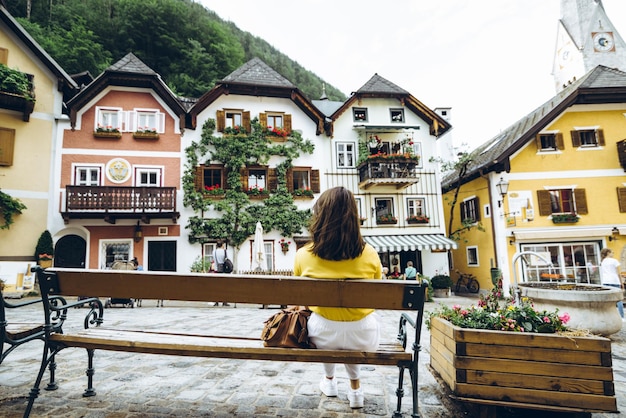 Woman sitting on the bench at hallstatt city central square summer travel vacation