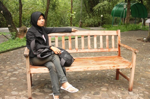 Photo woman sitting on bench in park