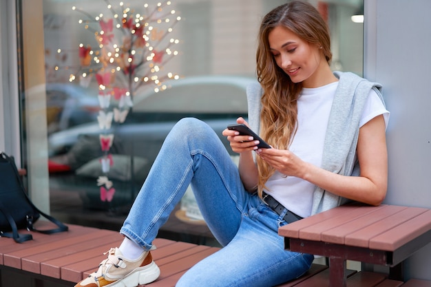 Woman sitting bench with smartphone