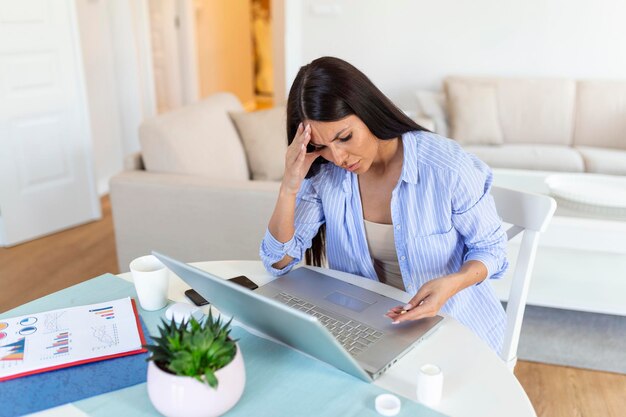 Woman sitting by the office desk and taking medical pills i\
hope this flu goes away quickly businesswoman having flu i should\
have taken a day off sick