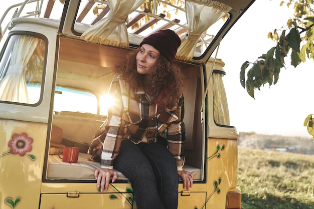 woman sitting by open door of retro camper van
