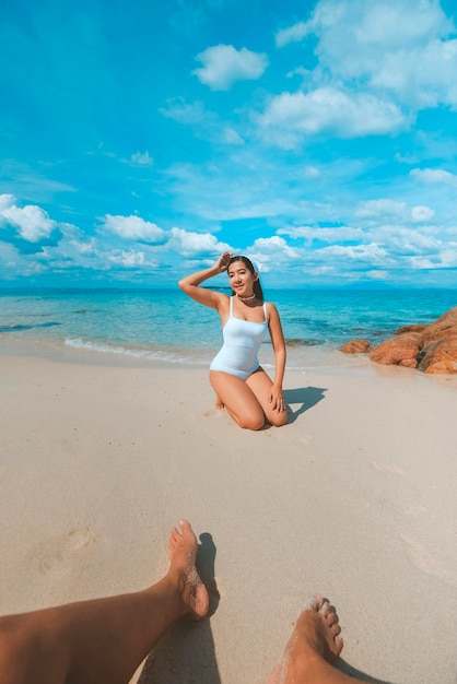 Фото Женщина сидит у моря, наслаждаясь видом на синее море на пляже. фотографии путешествий и отдых в кхо мун норк, таиланд.