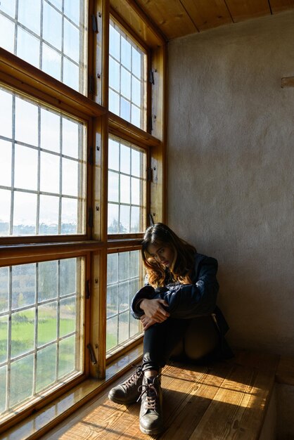 写真 家の窓のそばに座っている女性