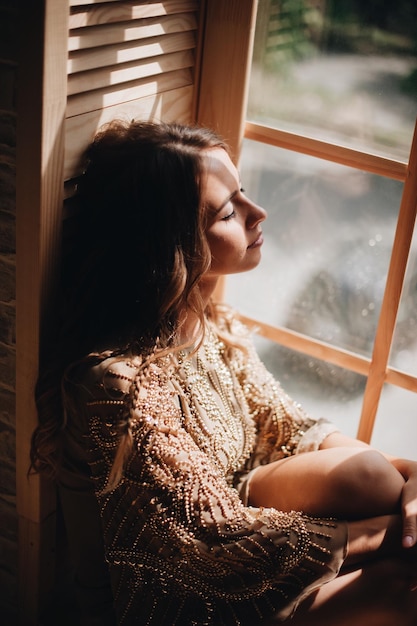 Photo woman sitting by window at home