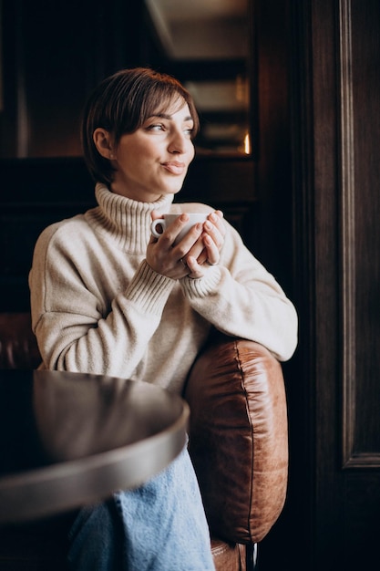 カフェに座ってコーヒーを飲む女性