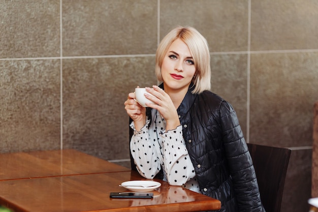 カフェに座ってコーヒーを飲む女性