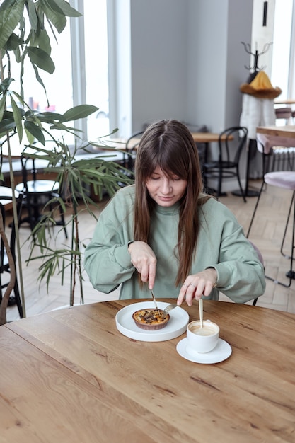 Donna seduta al caffè e mangiare la torta