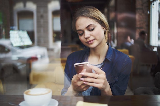 朝の軽食を食べるカフェのテーブルに座っている女性のライフスタイルレジャー社交