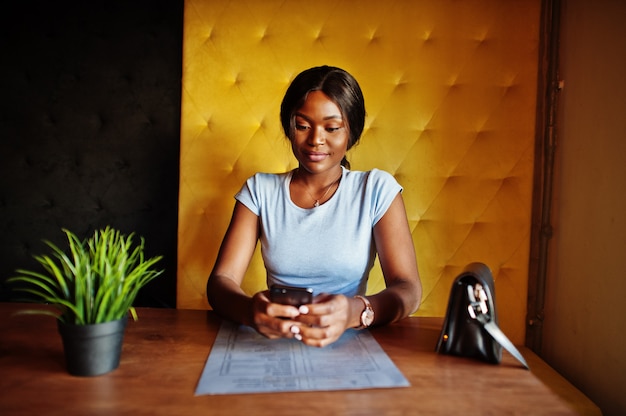 Woman sitting at cafe with mobile phone