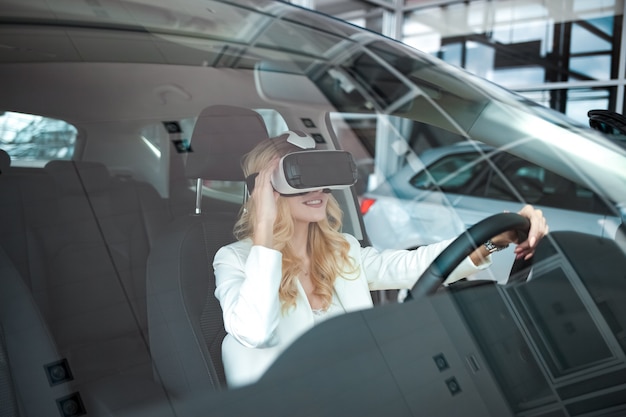 Woman sitting in a car in 3D glasses of virtual reality