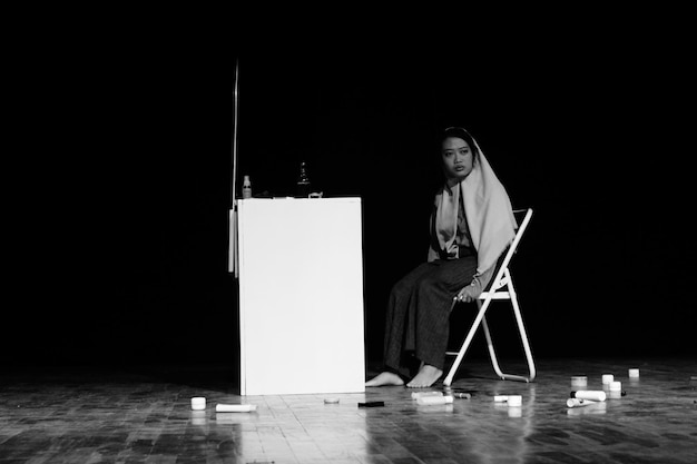 Photo woman sitting on chair in darkroom