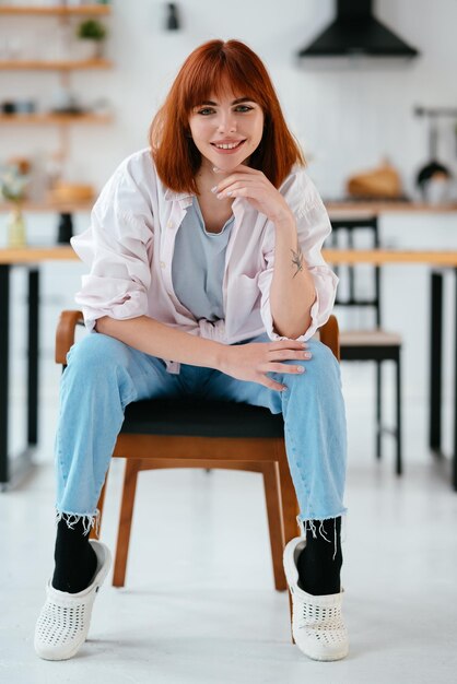 Woman sitting on a chair in a modern kitchen