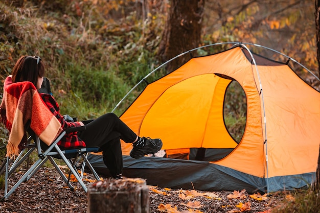 Woman sitting on the chair near tent