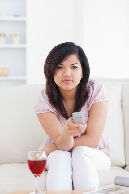 Woman sitting on a couch holding a remote