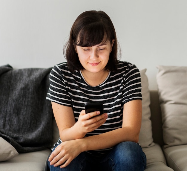 woman sitting on a couch using smartphone