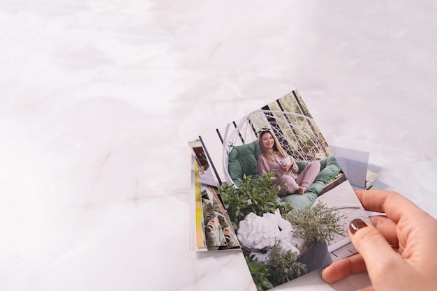 Woman sitting at desk and looking at printed photos remember nostalgia for a day of rest photography cards background Mock up