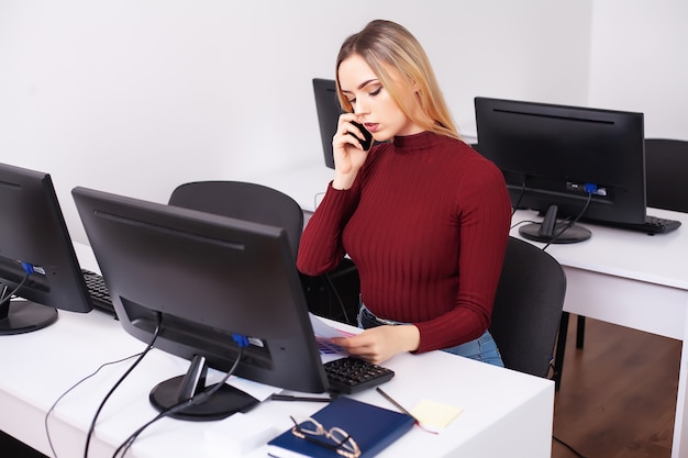 Woman sitting at desk, working on laptop in modern office