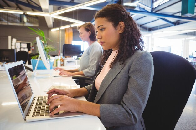 Woman sitting at desk and working on laptop