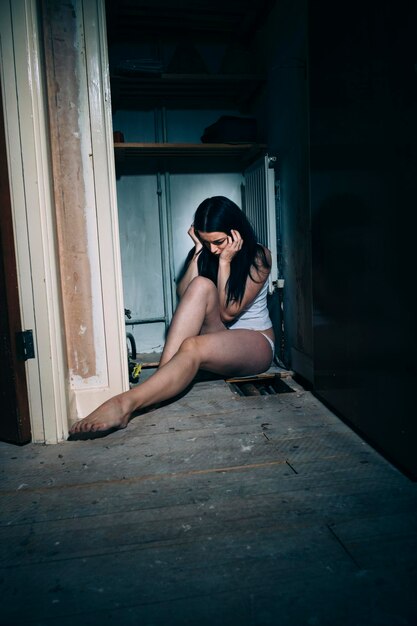 Photo woman sitting on entrance of door