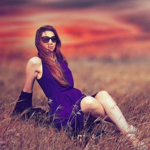 Photo woman sitting on field