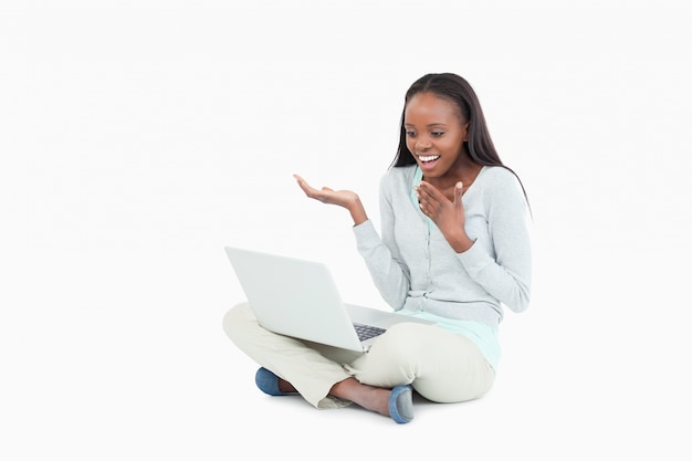 Woman sitting on the floor looking at her laptop