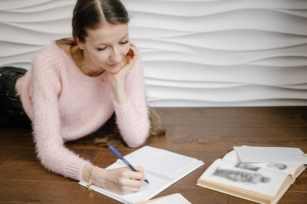 Woman sitting on the floor and reading book