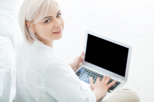 Woman sitting on the floor and using her laptop