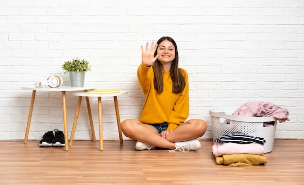 Woman sitting on the floor with a clothes basket