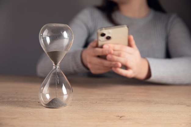 Woman sitting in front of an hourglass