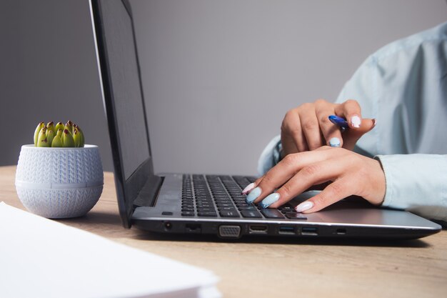 Женщина сидит перед ноутбуком и изучает данные в офисе