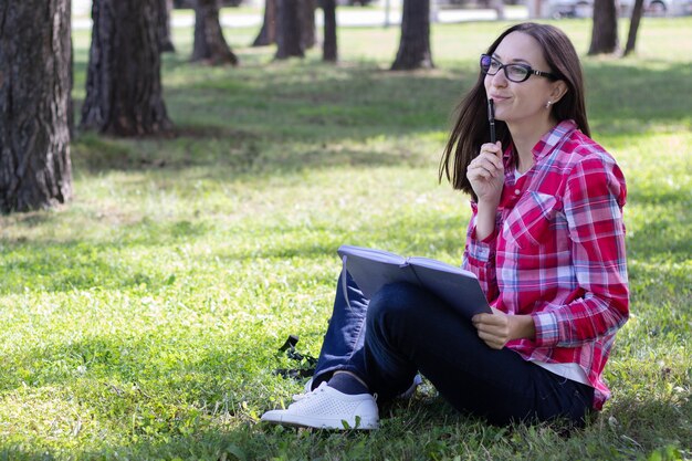 woman sitting on the grass and reading book