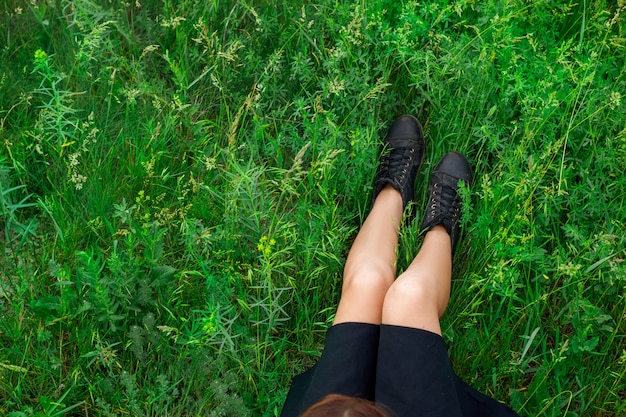 Woman sitting on green grass top view