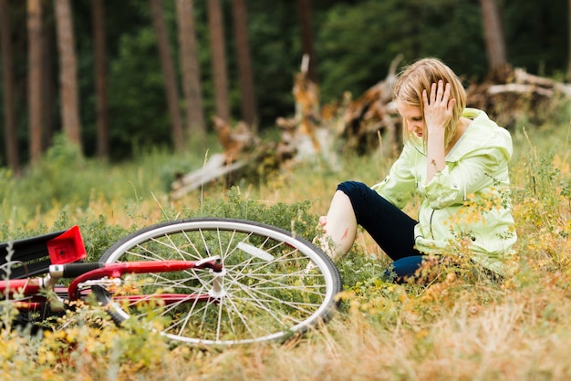 Woman sitting on ground with an injury