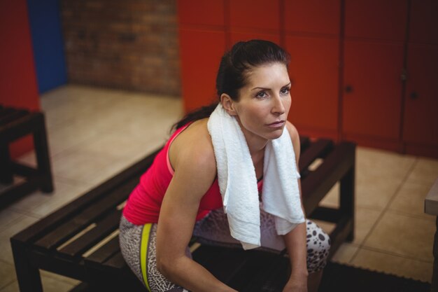 Woman sitting in gym locker room after workout