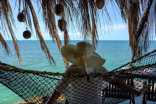 Photo woman sitting in hammock at beach