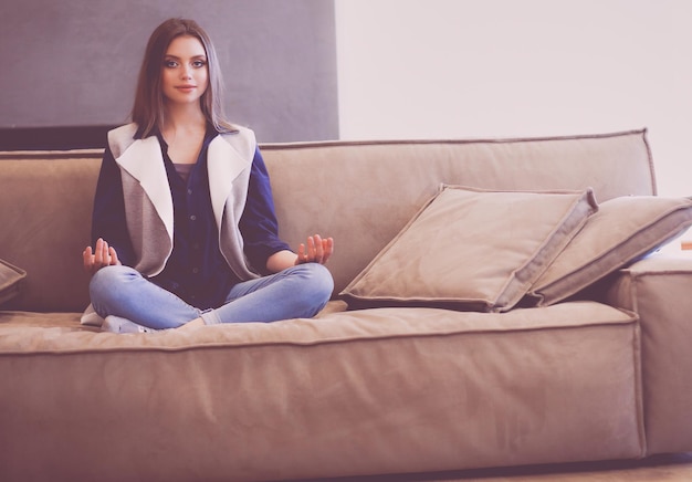 Woman sitting on her white sofa in white pullover