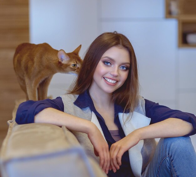 Photo woman sitting on her white sofa in white pullover