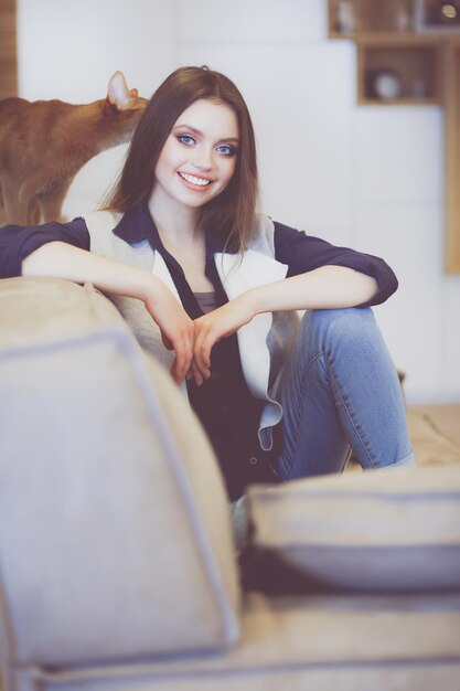 Woman sitting on her white sofa in white pullover