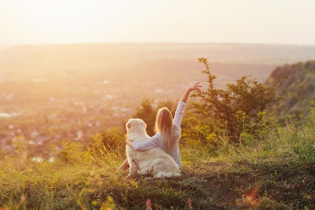 woman sitting on the hill with his dog