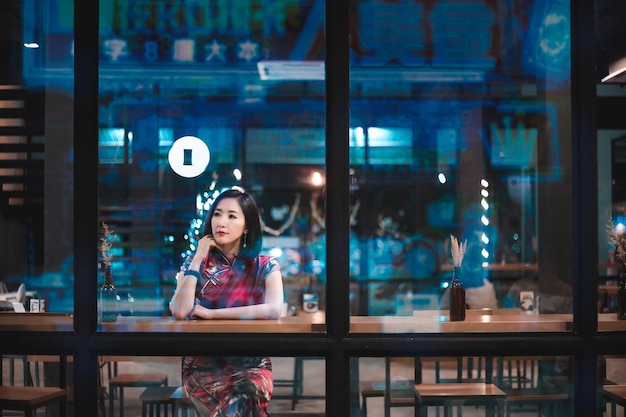 Photo woman sitting at illuminated restaurant