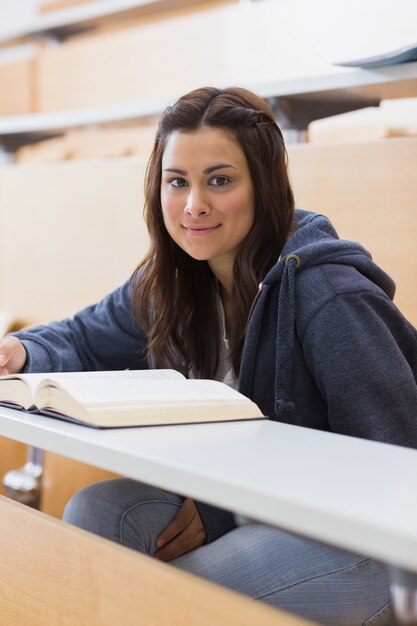 Woman sitting at the lecture hall reading 