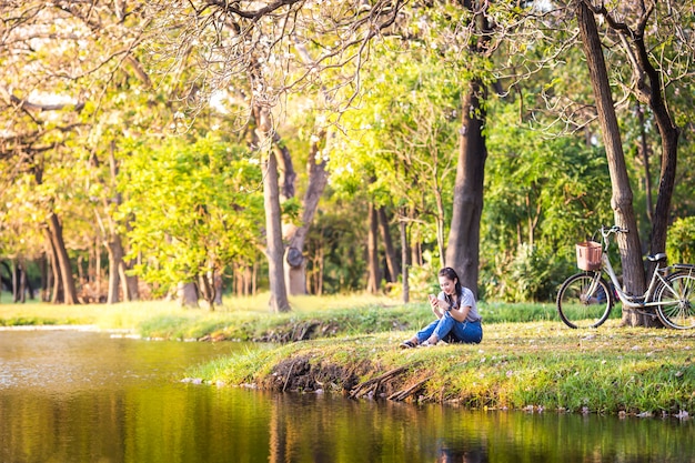 Woman sitting listening to music in the garden at sunset.