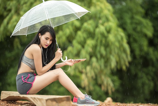 여자가 우산 외로운 앉아. 휴식의 개념