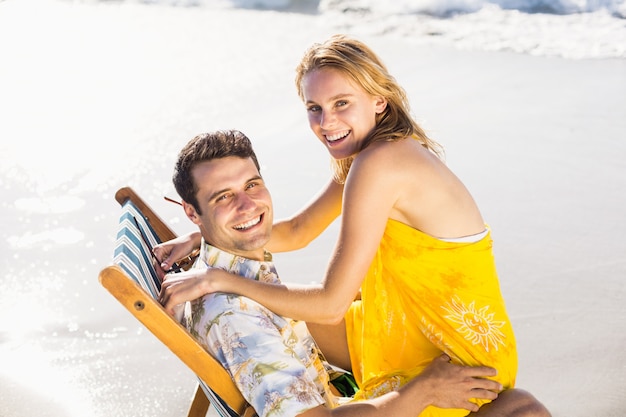 Woman sitting on mans lap at beach