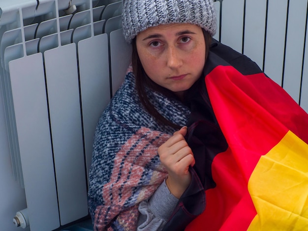 독일 국기로 덮인 배터리 근처에 앉아 있는 여성